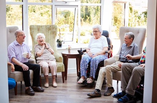 A group of senior citizens sitting together in a group in a senior living community.