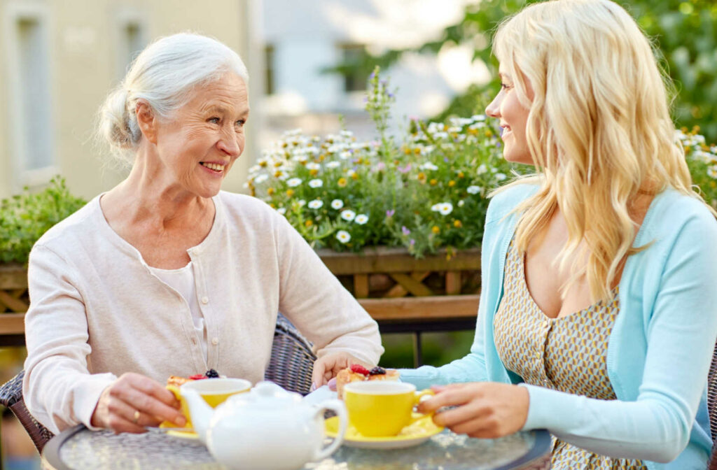 A woman having tea with her elderly mother.