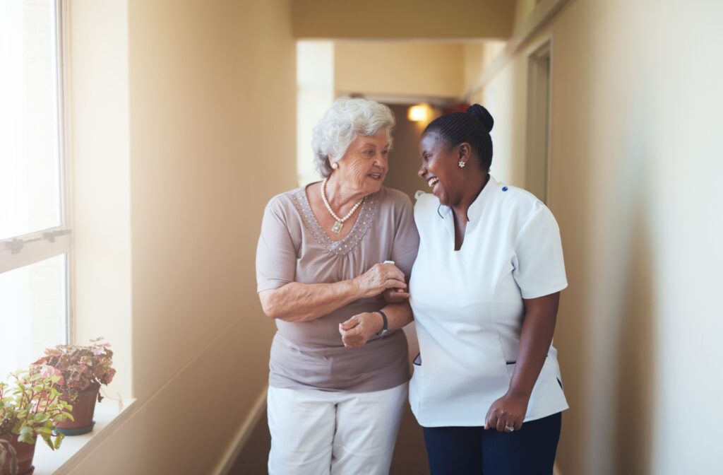 An older adult woman having a conversation with a happy assisted living nurse.