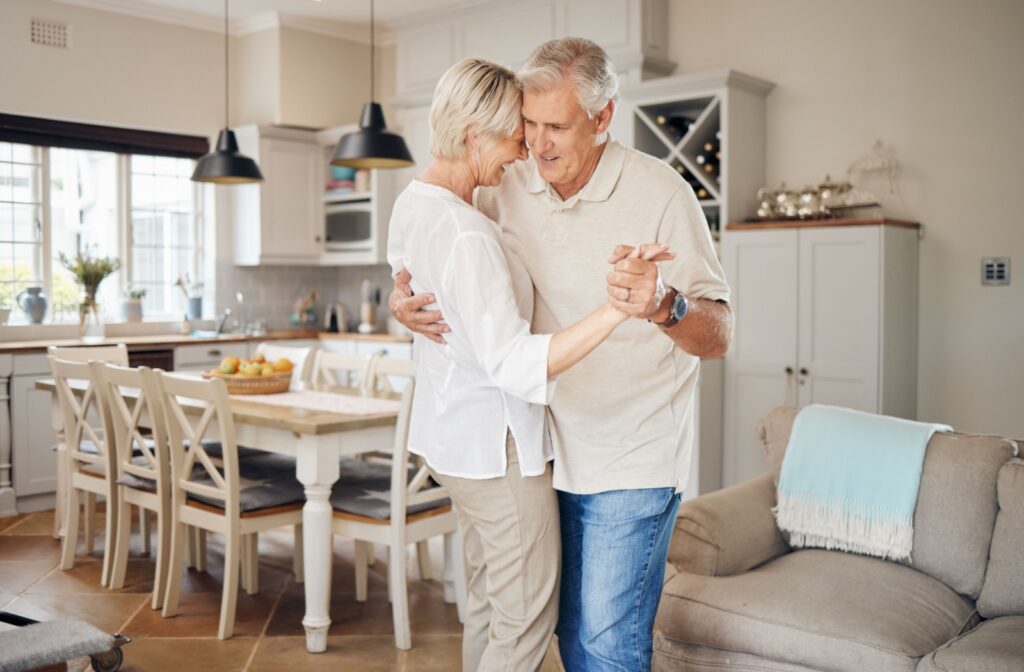 Mature couple dancing together in the kitchen.