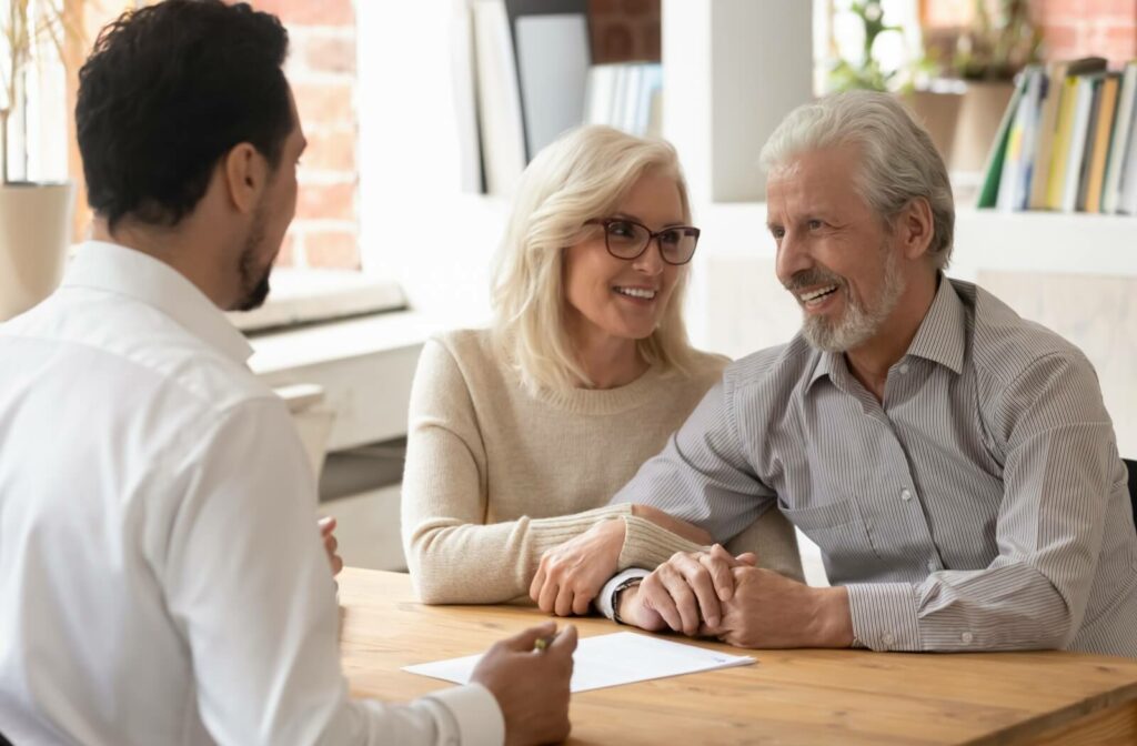  A mature couple explores the details of assisted living with a community staff member.