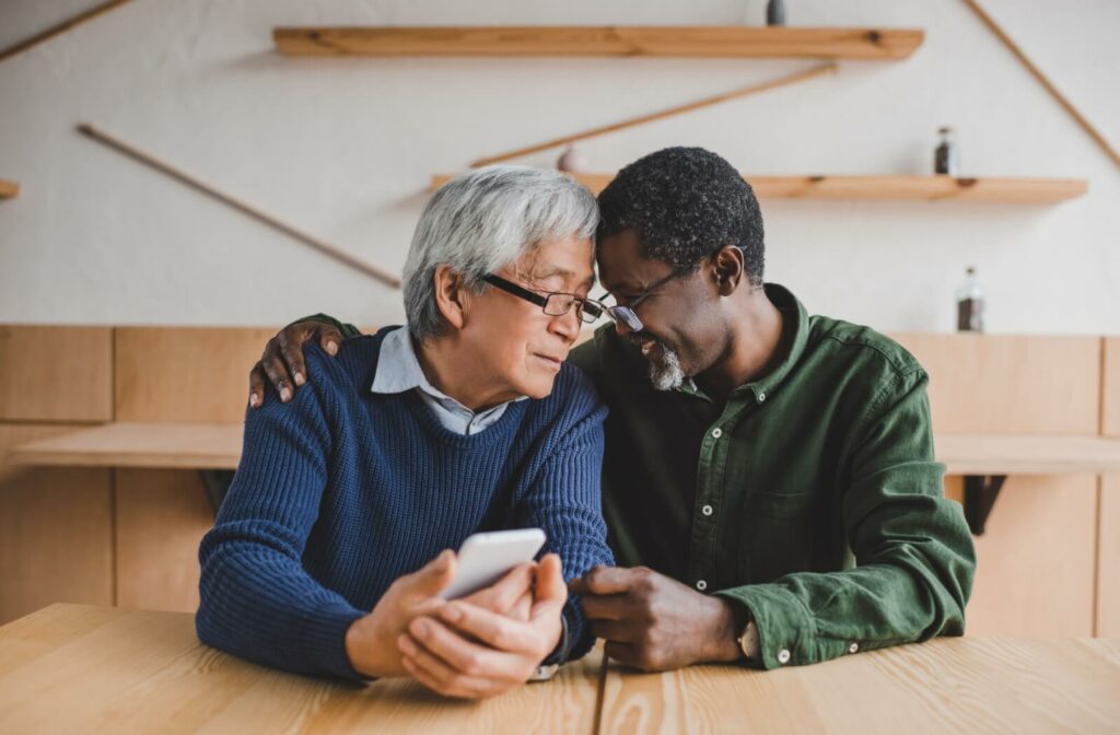 A senior couple touch their foreheads together, after a phonecall that secured their new independent living home
