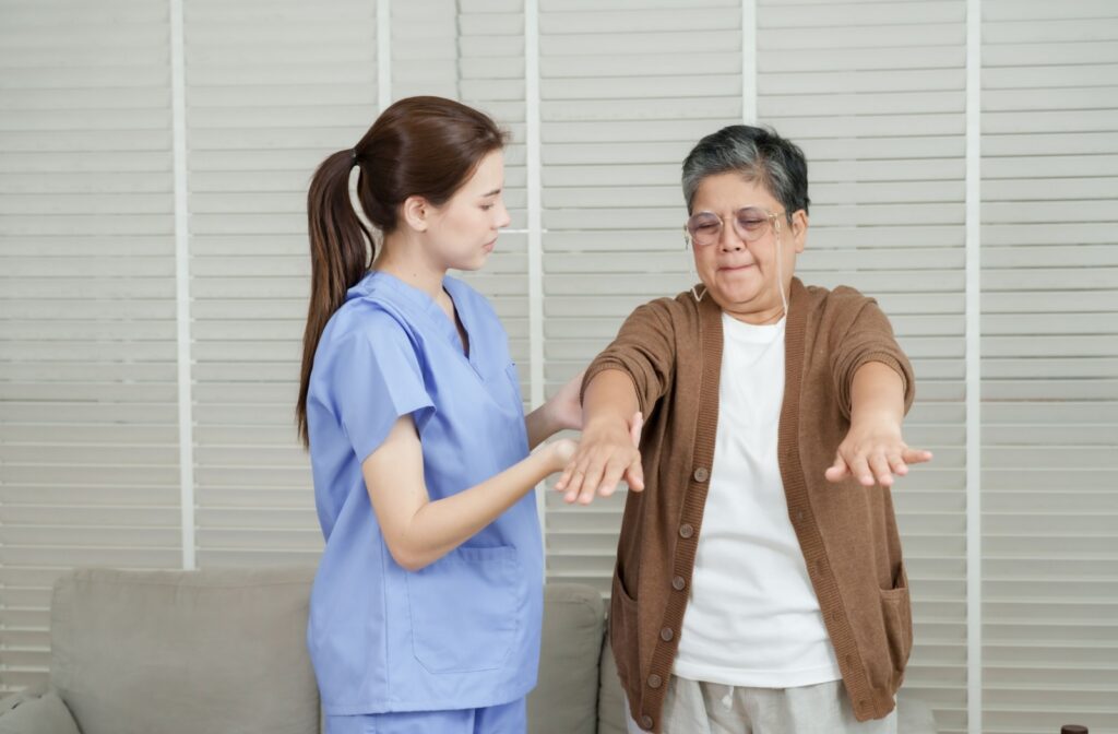 A senior living caregiver helps a resident with a low-impact stretching and mobility routine